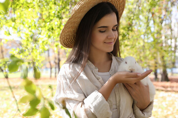 Wall Mural - Woman holding cute white rabbit in park