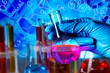 © New Africa - Scientist holding flask, test tubes and different chemical formulas, reactions and icons, multiple exposure