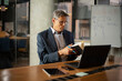 © JustLife - Businessman working with laptop at office. Businessman sitting at office desk working on laptop computer