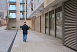 Fototapeta Na drzwi - man from behind walking on the street of new residential