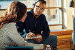 © Flamingo Images - Two African American businesspeople talking together during an office meeting