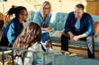 © Flamingo Images - Smiling businesspeople discussing paperwork together during an office meeting