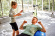 © Flamingo Images - Fitness instructor in gym doing exercise with man
