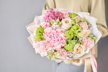 Wall Mural - Florist woman creates beautiful bouquet of mixed flowers with hydrangea, lilac and peony roses by David Austin. European floral shop concept. Handsome fresh bunch. Education, master class and