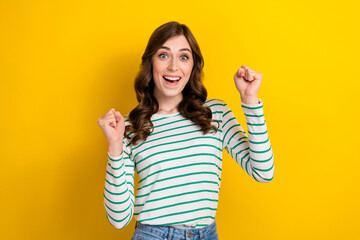 Sticker - Photo portrait of pretty young girl raise fists celebrate success lottery dressed stylish striped look isolated on yellow color background