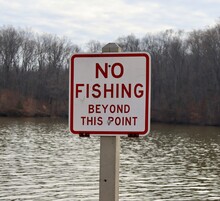 A Close View On The Red And White No Fishing Sign.