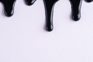 black liquid drops of paint color flow down on white canvas. abstract art. black paint dripping on t