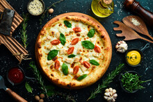 Pizza With Chicken, Tomatoes And Spinach. Classic Pizza On A Black Stone Background. Top View.