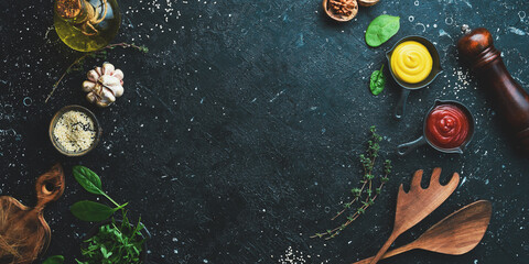 Wall Mural - Cooking background. Spices, vegetables and herbs. On a black stone background. Top view.