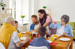 © Studio Romantic - Happy big family having lunch at table at home. Cheerful grandparents, mom, dad, their son and daughter eating and communicating. Family enjoying weekend or celebrating holidays together