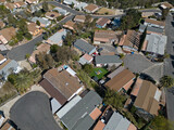 Fototapeta Miasto - A mobile home neighborhood is shown from an aerial, daytime view among the community's streets and cul-de-sacs.