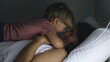 © Marco - Son jumping on mother laying in bed at night before sleep. Little boy and parent lifestyle moment