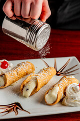 Wall Mural - Cannoli. Classic traditional Italian dessert. Italian pastries made with tube-shaped shells of fried pastry dough filled with a sweet, creamy ricotta filling. Traditional Sicilian dessert.