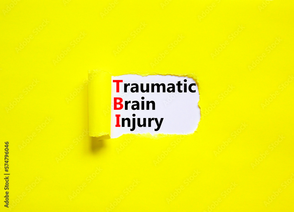 TBI traumatic brain injury symbol. Concept words TBI traumatic brain injury on white paper on a beautiful yellow background. Medical and TBI traumatic brain injury concept. Copy space.