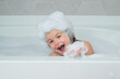 Kids shampoo. Kid bathing in a bath with foam. Funny kid face bathed in the bath.