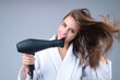 Woman with hair dryer on studio background. Girl hold hairdryer. Young woman drying hairs with hair dry machine. Beauty girl using dries hairs with hair dryer. Beauti model with holding blow dryer.
