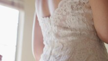 Close Up Womans Hands Zipping Up Back Of Lacy Wedding Dress For Bride