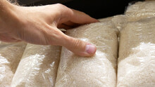 Close-up Of Many Rice Packagings And A Male Hand Takes One