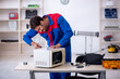 © Elnur - Young male repairman repairing oven at workshop