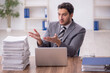 © Elnur - Young male employee and too much work in the office