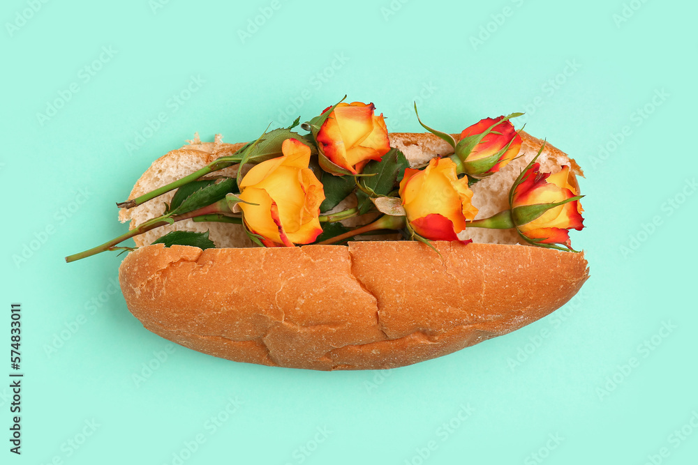 Hot dog with beautiful rose flowers on color background
