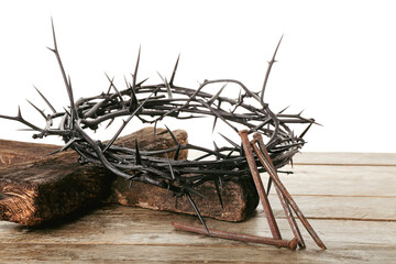 Wall Mural - Crown of thorns with nails and wooden cross on table against white background