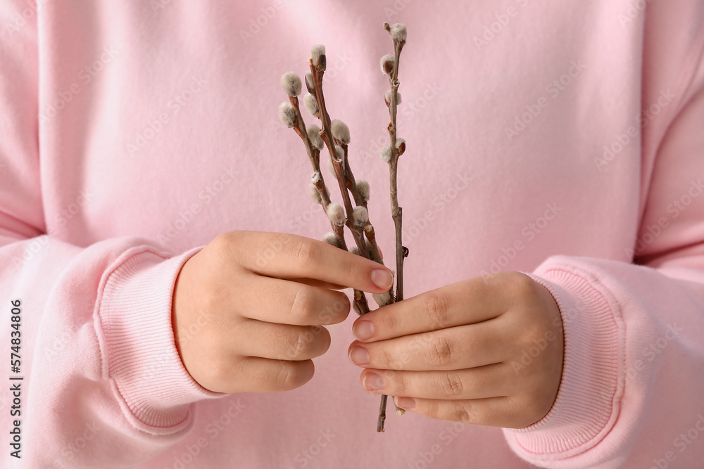 Woman in pink sweater holding willow branches