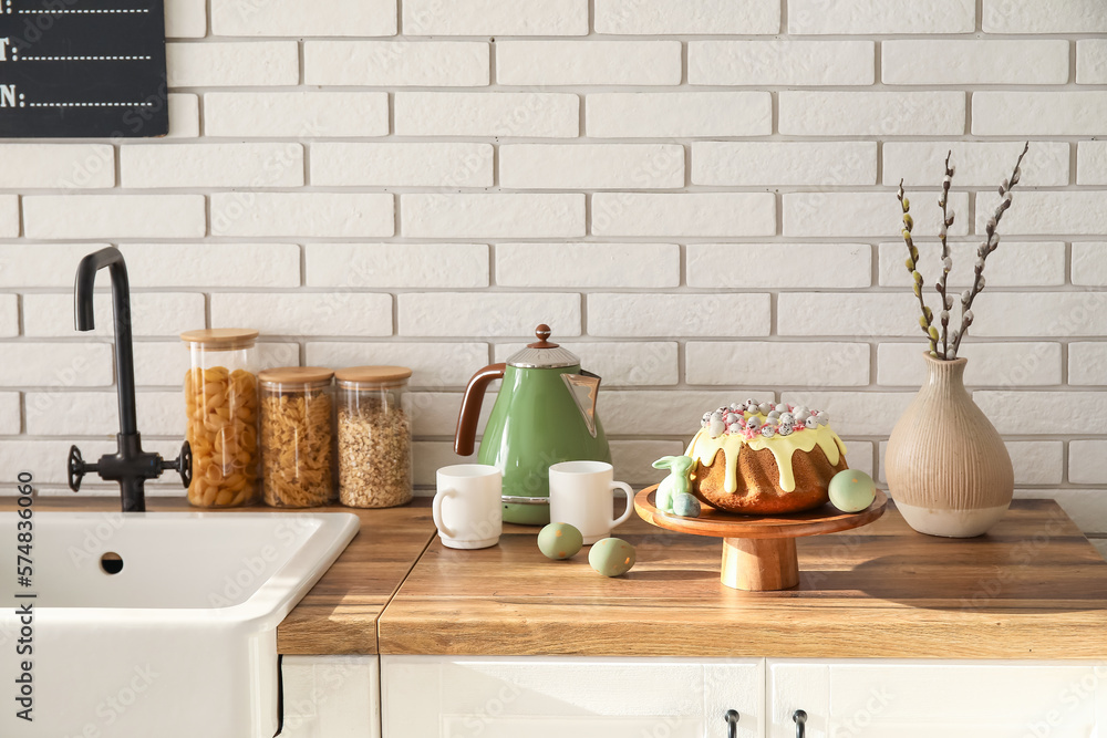Dessert stand with Easter cake, painted eggs and bunny on kitchen counter