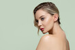 © Alena - Beautiful woman with clean skin standing in profile on a green background. Copyspace