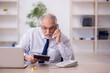 © Elnur - Old male boss working at workplace