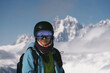 © Annatamila - Face portrait of Snowboarder female beautiful mountain peaks covered with snow on background