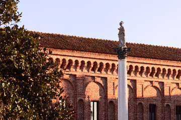 Wall Mural - The column with the statue of Minerva (Colonna di Minerva) stands on the square in front of the Galleria degli Antichi in Sabbioneta, Lombardy, Italy.