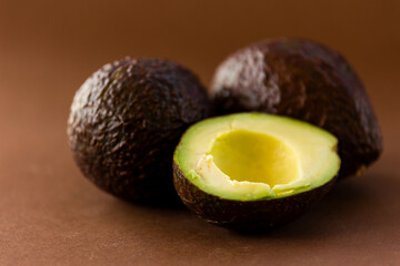 Wall Mural - close up fresh avocados on brown background