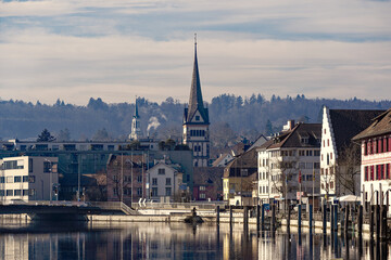 Wall Mural - Scenic view of the old town of City of Schaffhausen with Minster church and Rhine River in the foreground on a sunny winter day. Photo taken February 16th, 2023, Schaffhausen, Switzerland.