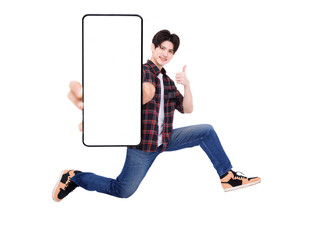 Happy young man jumping and showing blank mobile phone screen