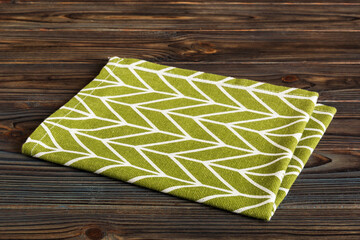 Poster - top view with green kitchen napkin isolated on table background. Folded cloth for mockup with copy space, Flat lay. Minimal style