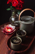 Green tea with leaves in a teacup and Asian style teapot with a wooden background