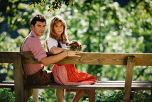 Couple In Traditional Clothing On Bench