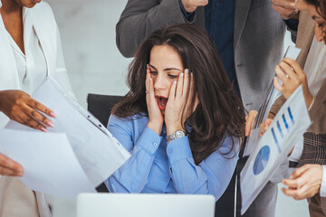 Wall Mural - Shot of a young businesswoman looking anxious in a demanding office environment. Frustrated millennial female worker felling tired of working quarreling. 