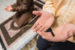 © LIGHTFIELD STUDIOS - Partial view of man with prayer beads praying near blurred son at home.