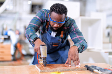 in work place carpenter man concentrate working using pneumatic nail gun drive nail to the wood