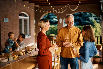 Wall Mural - Happy senior man talks to his daughter and granddaughter on patio.