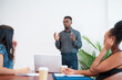 © Meeko Media - Black businessman leads meeting giving presentation in the office boardroom