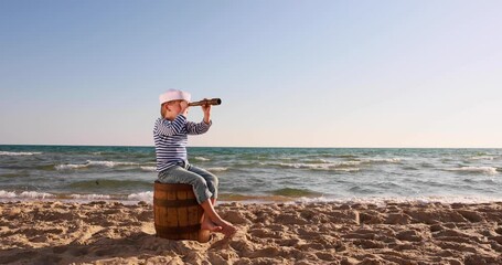 Wall Mural - Child looking through spyglass. Summer vacation and travel concept. Slow motion