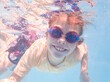 © Austockphoto - Smiling young Australian girl swimming in pool with goggles on in summer