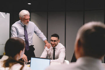 Wall Mural - Male director touching shoulder of employee during meeting in boardroom