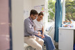 © Austockphoto - Male doctor holding a tablet  and talking to a female patient in the clinic
