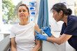 © Austockphoto - Female patient getting an injection on the arm by a female healthcare practitioner in a clinic