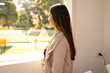 © Austockphoto - Indian woman standing by the window looking outside on a sunny day