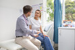 © Austockphoto - Male doctor holding a tablet  and talking to a female patient in the clinic